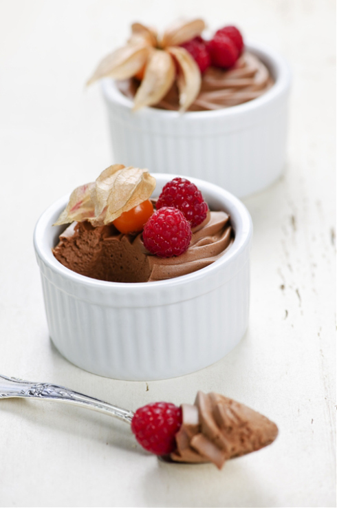 Two chocolate mousse desserts with a spoon